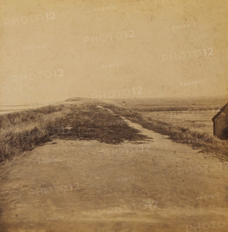 Just wide enough, View of the dune strip near Ter Heijde, Views and landscapes in Europe, Africa and Asia, Geographical Sculpture Gallery, collected by MJ Broekhuijsen, Headmaster of a school in Amsterdam, stereograph, Numbered A.4. at the bottom left of the photo, annotation: 'is near Ter Heijde the dune strip, continually excavated further by humans, to enlarge the area of the geestgronden on the right. Compare the height of the sea level and of the geestgrond., Rectangular on the dune strip in the sea are the piers.', Ter Heijde, publisher: Merkelbach & Co., Amsterdam, compiler (person in literature): Martien Johan Broekhuijsen, c. 1905, photographer, compiler (person in literature), pasteboard, paper, albumen print, height 86 mm x width 176 mm, Part of a group of 52 stereophotos used in primary education as a supplement to school charts. The entire series consisted of 274 items in 10 categories (A to K)., Dune Coast, A wide, sandy pathway extends from the foreground toward the hori...