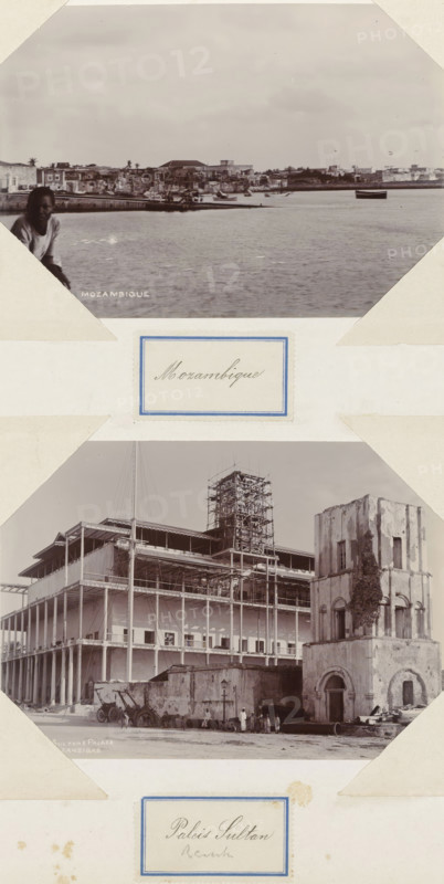 View of a coastal town in Mozambique, Mozambique, photograph, Part of Album with 191 photographs of a trip to and through South Africa., c. 1900 - c. 1920, photographer, paper, daylight gelatin silver print, height 107 mm x width 152 mm, prospect of city, town panorama, silhouette of city, A vertical composite of two sepia photographs mounted on paper with decorative labels, the top photograph showing a waterfront scene with calm water in the foreground, a shoreline with low buildings and scattered trees in the middle ground, a small boat floating on the water toward the right, and a person partially visible at the lower left edge leaning against the frame, and the bottom photograph showing a large multi-story building under construction with exposed columns and scaffolding around a central tower, adjacent to an older weathered stone structure with arched openings, construction materials and large pipes on the ground, and several people standing and sitting near the buildings.