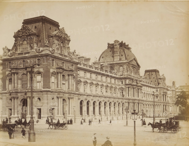 Musée du Louvre in Paris, album page, photograph, This photo is part of an album., 1880 - 1910, photographer, paper, albumen print, height 214 mm x width 274 mm, permanent exhibition, museum, four-wheeled, animal-drawn vehicle, eg: cab, carriage, coach, civic architecture, edifices, dwellings, Paris, Musée du Louvre, A large ornate stone building with arched windows and columns runs across the image, featuring sculpted figures and decorative reliefs along its upper facade and a domed roof section with detailed ornamentation; a wide street in front shows several horse-drawn carriages and groups of pedestrians dressed in period clothing, with tall lampposts lining the pavement and a few trees visible at the far right.