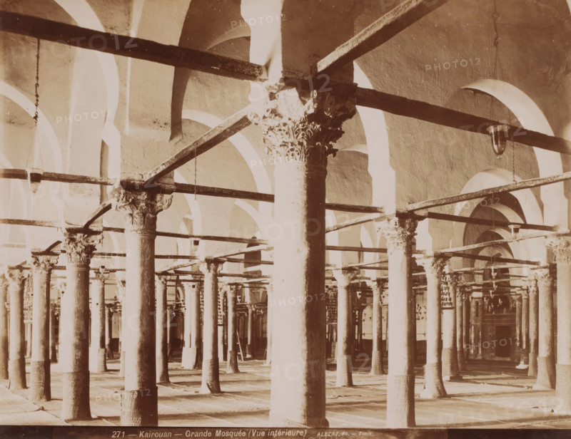 Kairouan, Grande Mosquée (vue intérieure), Courtyard of the Great Mosque of Kairouan, photograph, number: '271', photographer: Albert Goupil, 1860 - 1900, North Africa, pasteboard, paper, albumen print, height 247 mm x width 317 mm, temple, shrine, Islam, Mohammedanism, Great Mosque of Kairouan, The image shows rows of tall columns with carved capitals supporting horizontal beams and a series of rounded arches in a large, open interior space, with hanging light fixtures suspended from some beams and patterned bases at the foot of several columns.