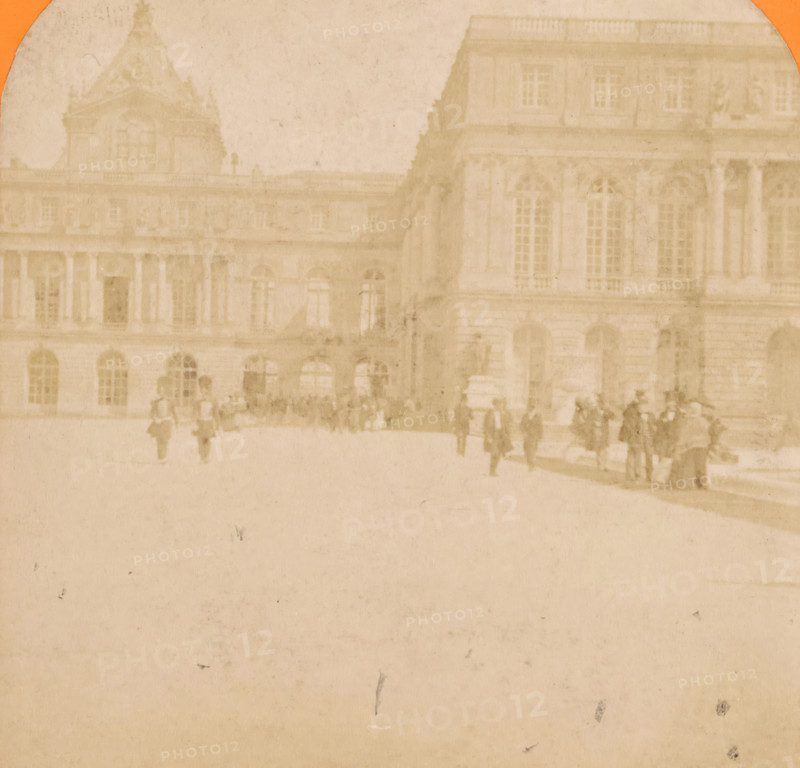 View of the chapel of the Palace of Versailles, stereograph, inscription: 'Versailles', Versailles, c. 1850 - c. 1880, photographer, paper, pasteboard, albumen print, height 87 mm x width 177 mm, palace, parts of church exterior and annexes: chapel, Palace of Versailles, A faded sepia-toned photograph shows a large classical stone building with tall arched windows and decorative architectural details, a section with columns and a pedimented roof barely visible against a pale sky, and in front of the building a group of indistinct figures and small groups of people scattered across a courtyard area, their forms blurred and softened by age and discoloration.