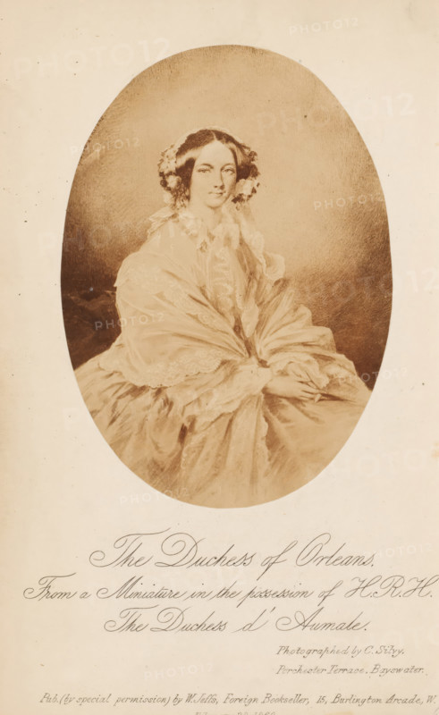 Photo reproduction of a miniature of the Duchess of Orléans, photograph, reproduction, page, inscription: 'From a Miniature in the possession of HRH, The Duchess d'Aumale., Photographed by C. Silvy., Porchester Terrace, Bayswater., Pub. (by special permission) by W. Jeffs, Foreign Bookseller, 15, Burlington Arcade, W., February 28. 1860.', photographer: Camille Leon Louis Silvy, after painting by unknown, 1855 - in or before 1860-02-28, Camille Leon Louis Silvy, unknown, photographer, after painting by, paper, albumen print, albumendruk, height 122 mm x width 87 mm, Photo opposite title page., Person, Helene van Mecklenburg-Schwerin, historical persons - BB - woman, painting (including book-illumination, miniature-painting), A sepia-toned oval portrait of a seated woman wearing a voluminous lace-trimmed gown and a shawl, her hair styled with floral adornments at the sides, hands gently folded in her lap, set against a plain darker background and surrounded by a lighter rectangular bord...