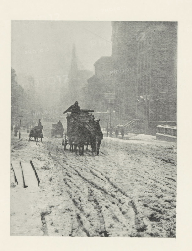 L'Hiver, cinquième avenue, Fifth Avenue in the snow, New York, photomechanical print, photographer: Alfred Stieglitz, New York (city), cliché maker: Fillon & Heuse, printer (person): Charles Wittmann, Paris, 1893 - in or before 1896, Alfred Stieglitz, Fillon & Heuse, Charles Wittmann, photographer, cliché maker, printer (person), North America, paper, photoaquatint, height 161 mm x width 124 mm, street, snow, four-wheeled, animal-drawn vehicle, eg: cab, carriage, coach, Manhattan, Fifth Avenue, A snowy street scene shows a slushy road with deep tire and hoof tracks leading into the distance, flanked by tall, shadowy buildings on the right and faint building outlines on the left; in the middle distance a horse-drawn wagon with a covered load is traveling away from the viewer with a driver perched atop, and other carriages and figures are scattered along the street, some near sidewalks and some barely visible in the mist; snow covers the ground and the lower steps of buildings, and the a...