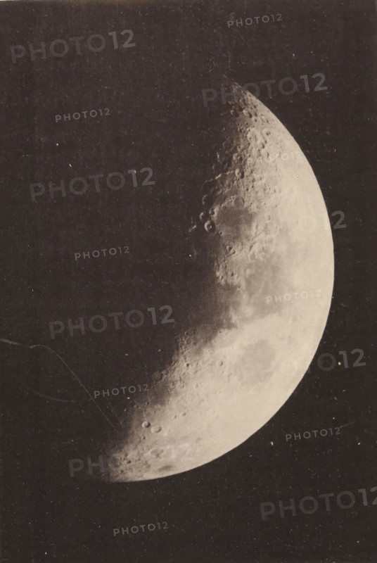 La lune, Maan, page, photomechanical print, inscription: 'Agrandissement direct, Réfrateur astrophotographique de Grubb., (Ouverture 22.5 centimètres.)', photographer: Wilhelm Prinz, Brussels, cliché maker: Joseph Maes, c. 1887 - in or before 1889, paper, collotype, photoprint, height 144 mm x width 99 mm, Print on unnumbered page opposite page 704., moon as celestial body, Moon, A monochrome photograph shows a crescent celestial body with a textured, cratered surface against a dark background, occupying the right side of a rectangular frame; the surrounding border is lighter and there is printed material below the image.