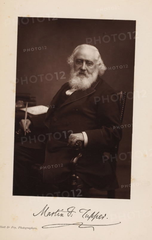 Portrait of Martin Farquhar Tupper, page, photomechanical print, inscription: 'Martin F. Tupper', photographer: Elliott & Fry, cliché maker: anonymous, c. 1881 - in or before 1886, paper, Woodburytype, height 145 mm x width 96 mm, Print opposite title page., Person, Martin Farquhar Tupper, portrait of a writer, An older man with a full white beard and wavy white hair sits in a dark suit on a carved wooden chair, one hand resting on the armrest and the other holding a slender object above a table with a book or papers, all set against a plain dark background.