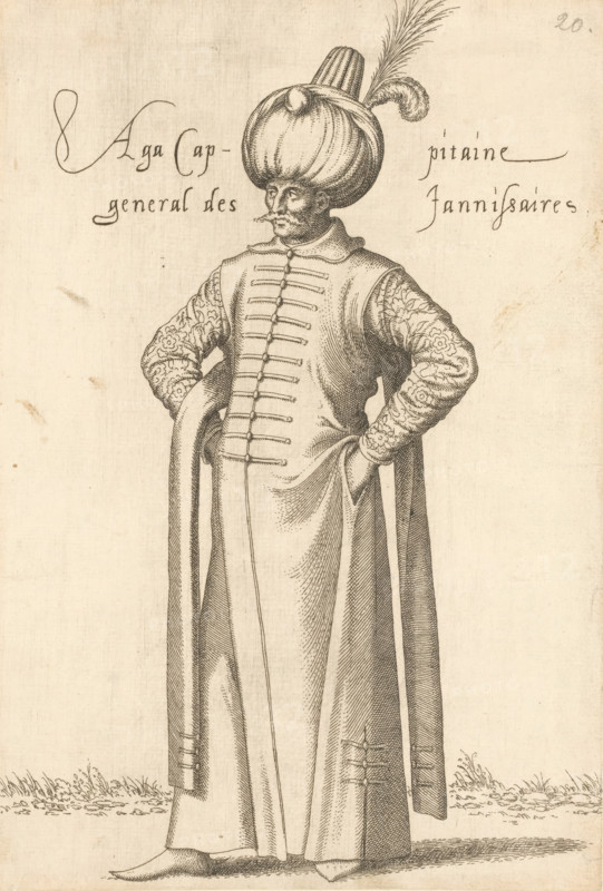 Aga, cappitaine général des jannissaires, 'Aga' (commander in chief) of the janissaries, print, album page, book illustration, Print is part of an album., printmaker: Léon Davent, after drawing by Luca Penni (attributed to), after drawing by Nicolas de Nicolay (possibly), publisher: Guillaume Rouille (I), Lyon, 1555 - 1568, Léon Davet, Attributed to, paper, etching, mounted on album page, height 260 mm x width 176 mm, A tall figure stands facing forward wearing a long flowing robe with a buttoned front and wide sleeves, hands tucked into the robe at the hips, patterned sleeves with floral-like designs, a large rounded turban topped with a tall cylindrical element and a long feather, a narrow mustached face with a prominent nose, shoes partly visible beneath the robe, simple ground with small tufts of grass around the feet, and faint handwritten markings near the upper edges of the page.