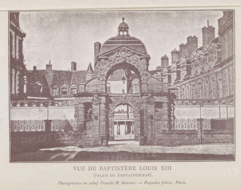 View of the entrance gate of the castle of Fontainebleau, Vue du Baptistère Louis XIII (Palais de Fontainebleau), page, photomechanical print, Fontainebleau, cliché maker: Dujardin Frères, Paris, c. 1859 - in or before 1869, photographer, paper, photoaquatint, photogravure and relief process H. Garnier, height 98 mm x width 147 mm, façade (of house or building), gate, entrance, Palais de Fontainebleau, A monochrome image showing an ornate stone gateway with a large rounded arch topped by sculpted reliefs and a domed pavilion above, flanked by stone columns and decorative balustrades, with an iron fence in front and architectural facades with rows of windows and chimneys extending on both sides behind the gateway, and a courtyard visible through the arch.