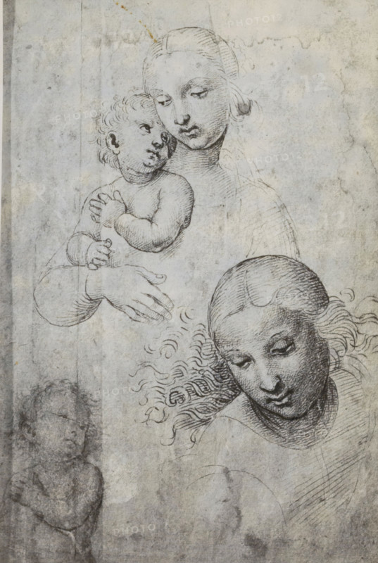Photo reproduction of a drawing depicting Mary and Child, photograph, reproduction, page, photographer: Adolphe Braun & Cie., after drawing by Rafaël, c. 1859 - in or before 1869, paper, carbon print, height 119 mm x width 119 mm, Madonna: ie Mary with the Christ-child, A pencil or ink drawing on aged paper shows a seated woman holding a baby against her chest, the woman's face turned slightly downward with a calm expression and hair drawn back, the baby looking up toward her with curly hair and chubby limbs, the woman's hands and the baby's hands rendered with careful line work, and below them another female head in three-quarter view with wavy hair flowing outward and a downward gaze; faint traces of additional sketch lines and smudges appear on the textured, stained background.