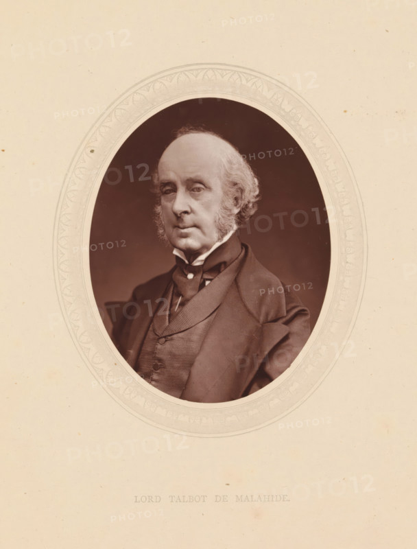 Lord Talbot de Malahide, page, photomechanical print, photographer: Lock & Whitfield, cliché maker: anonymous, c. 1871 - in or before 1876, paper, Woodburytype, height 115 mm x width 89 mm, Person, James Talbot, politician, eg party leader, historical persons (portraits and scenes from the life) ((full) bust portrait), An oval portrait of an older man with a receding hairline and sideburns set against a dark background, framed by a decorative oval mat on a light beige sheet, showing him wearing a dark coat, waistcoat, high collared shirt, and cravat, with a composed facial expression and direct gaze.