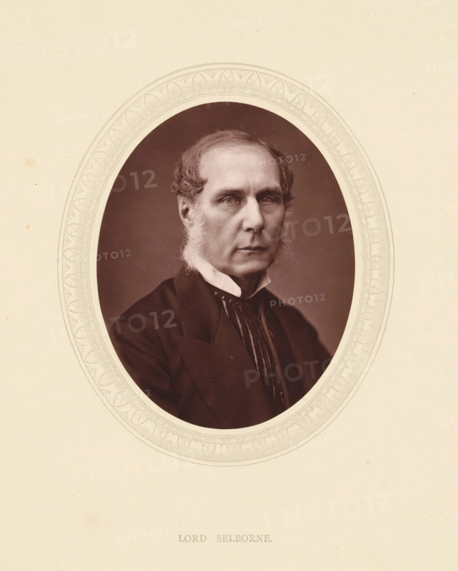 Lord Selborne, page, photomechanical print, photographer: Lock & Whitfield, cliché maker: anonymous, c. 1871 - in or before 1876, paper, Woodburytype, height 115 mm x width 89 mm, Person, Roundell Palmer (1st Earl of Selborne), politician, eg party leader, historical persons (portraits and scenes from the life) ((full) bust portrait), A sepia-toned oval portrait of an older man centered on a pale textured background, showing his head and upper torso facing forward with a neutral expression, short wavy hair, pronounced sideburns, and a high-collared shirt beneath a dark jacket, the oval frame featuring a delicate decorative border.