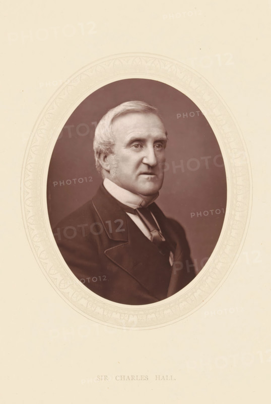 Sir Charles Hall, page, photomechanical print, photographer: Lock & Whitfield, cliché maker: anonymous, c. 1871 - in or before 1876, paper, Woodburytype, height 115 mm x width 89 mm, Person, Charles Hall, lawyer, attorney at law, historical persons (portraits and scenes from the life) ((full) bust portrait), An oval sepia portrait centered on a cream background shows an older man with light hair combed to the side and short sideburns, wearing a dark formal coat with wide lapels, a high white collar, and a tied cravat, his expression neutral and his gaze directed slightly to the viewer's left, framed by a decorative embossed oval border against the plain paper.
