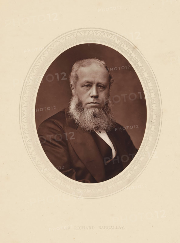 Sir Richard Baggallay, page, photomechanical print, photographer: Lock & Whitfield, cliché maker: anonymous, c. 1871 - in or before 1876, paper, Woodburytype, height 115 mm x width 89 mm, Person, Richard Baggallay, magistracy, judges, historical persons (portraits and scenes from the life) ((full) bust portrait), A sepia-toned oval portrait of a seated man with a full beard and moustache, wearing a dark suit jacket and a light-colored shirt with a vest, set against a plain dark background and framed by an ornate decorative oval border on a light paper background.
