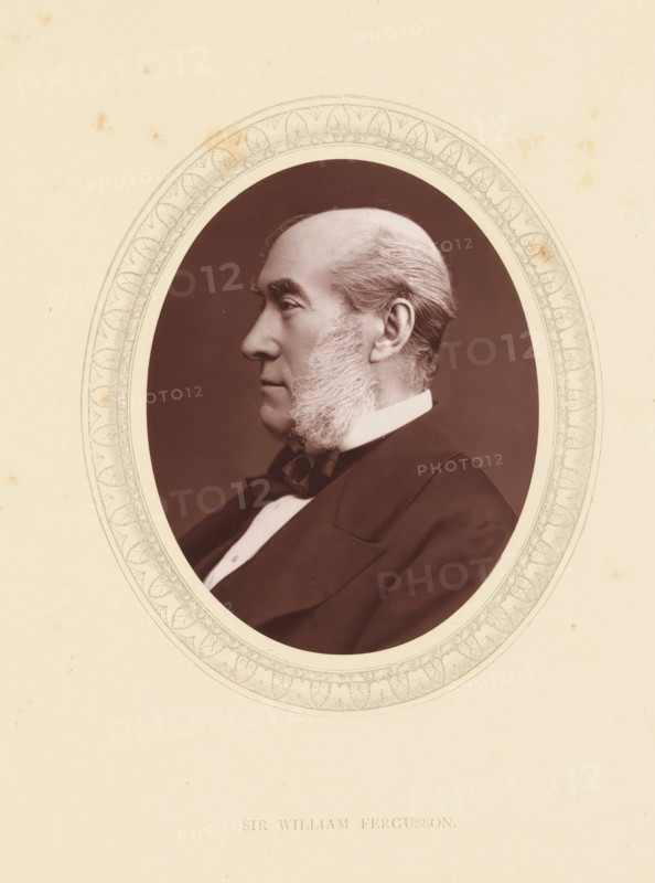 Sir William Fergusson, page, photomechanical print, photographer: Lock & Whitfield, cliché maker: anonymous, c. 1871 - in or before 1876, paper, Woodburytype, Woodbury Process, height 115 mm x width 89 mm, Person, William Fergusson, barber, surgeon, historical persons (portraits and scenes from the life) ((full) bust portrait), A sepia-toned oval portrait of an older man shown in profile facing left, framed by a decorative oval border with intricate floral and leaf patterns, set against a pale cream background with small scattered spots and stains; the man has a high forehead, swept-back hair, prominent sideburns that extend down his cheeks, a straight nose, and a closed-mouth expression, and he is wearing a dark suit jacket, a white shirt collar, and a bow tie.