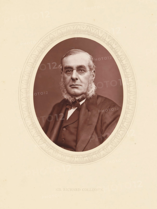 Sir Richard Collinson, page, photomechanical print, photographer: Lock & Whitfield, cliché maker: anonymous, c. 1871 - in or before 1876, paper, Woodburytype, Woodbury Process, height 115 mm x width 89 mm, Person, Richard Collinson, officer, historical persons (portraits and scenes from the life) ((full) bust portrait), An oval sepia portrait of a middle-aged man with sideburns and round spectacles set within an ornate oval mat against a light paper background, the man wearing a dark suit, waistcoat, and bow tie, facing forward with a neutral expression.