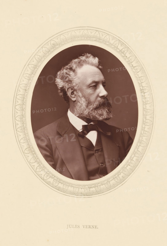 Jules Verne, page, photomechanical print, photographer: Antoine-Samuel Adam-Salomon, France, cliché maker: anonymous, c. 1871 - in or before 1876, paper, Woodburytype, Woodbury Process, height 115 mm x width 89 mm, Person, portrait of a writer, historical persons (portraits and scenes from the life) ((full) bust portrait), An oval photographic portrait centered on a light background showing a man in three-quarter profile facing right with curly hair and a full beard, wearing a dark suit jacket, waistcoat, white shirt, and a bow tie; the portrait is surrounded by a decorative oval border with repeating leaf-like patterns, and below the oval there is printed text.