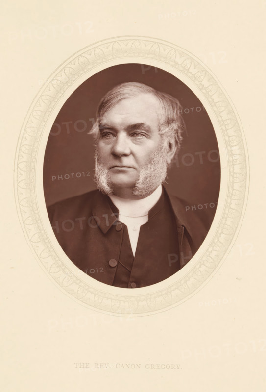 The rev. Canon Gregory, page, photomechanical print, photographer: Lock & Whitfield, cliché maker: anonymous, c. 1871 - in or before 1876, paper, Woodburytype, Woodbury Process, height 115 mm x width 89 mm, Person, Robert Gregory, priest (Roman Catholic), historical persons (portraits and scenes from the life) ((full) bust portrait), An oval sepia-toned portrait of a middle-aged man with sideburns set against a darker oval background, framed by an ornate pale border on a light background; he wears a dark coat with visible buttons and a high white collar, his hair is swept to the side, and his expression is neutral with eyes looking slightly to one side.