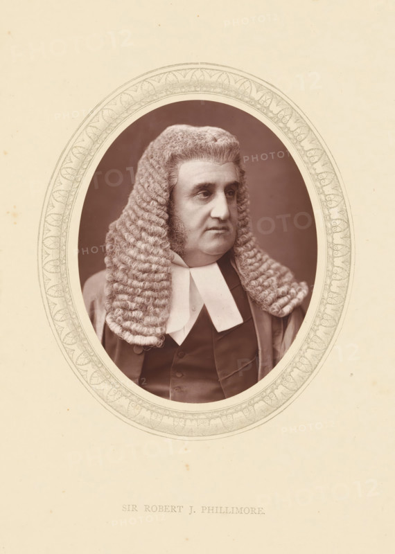 Sir Robert J. Phillimore, page, photomechanical print, photographer: Lock & Whitfield, cliché maker: anonymous, c. 1871 - in or before 1876, paper, Woodburytype, Woodbury Process, height 115 mm x width 89 mm, Person, Robert Phillimore, magistracy, judges, historical persons (portraits and scenes from the life) ((full) bust portrait), A sepia-toned portrait of a man shown from the chest upward inside an ornate oval frame, wearing a full curled judicial wig with tight rows of ringlets falling to his shoulders, a dark formal coat and a white collar with two flat tabs, the man looking slightly to his left with a neutral expression and visible sideburns, the oval frame set against a pale background with subtle speckling.