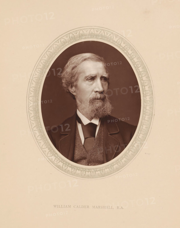 William Calder Marshall, RA, page, photomechanical print, photographer: Lock & Whitfield, cliché maker: anonymous, c. 1873 - in or before 1878, paper, Woodburytype, Woodbury Process, height 115 mm x width 89 mm, Person, portrait, self-portrait of sculptor, historical persons (portraits and scenes from the life) ((full) bust portrait), A sepia-toned oval portrait of a middle-aged man with wavy hair and a full beard, shown from the shoulders up, wearing a dark suit jacket, a vest, and a tie, framed by an ornate patterned oval border set against a plain light background.
