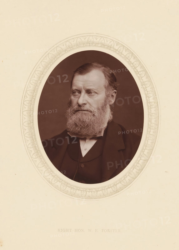 Right hon. WE Forster, page, photomechanical print, photographer: Lock & Whitfield, cliché maker: anonymous, c. 1873 - in or before 1878, paper, Woodburytype, Woodbury Process, height 115 mm x width 89 mm, Person, William Edward Forster, philanthropist, historical persons (portraits and scenes from the life) ((full) bust portrait), A sepia-toned oval portrait of a middle-aged man with a full beard and mustache, short combed hair, and a solemn expression, shown from the shoulders up wearing a dark suit jacket, waistcoat, and bow tie, set against a dark background and surrounded by a decorative oval border on a light paper background.