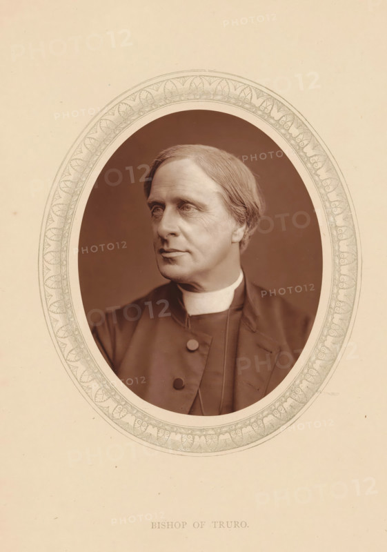 Bishop of Truro, page, photomechanical print, photographer: Lock & Whitfield, cliché maker: anonymous, c. 1875 - in or before 1880, paper, Woodburytype, Woodbury Process, height 115 mm x width 89 mm, Person, Edward Benson, archbishop, bishop, etc. (Roman Catholic), historical persons (portraits and scenes from the life) ((full) bust portrait), A sepia-toned oval portrait of a middle-aged person with short, neatly combed hair, shown from the chest up and turned slightly to the viewer's left, wearing a dark clerical garment with a high white collar and visible buttons, set against a plain dark background and framed by a decorative oval border on a light paper background.