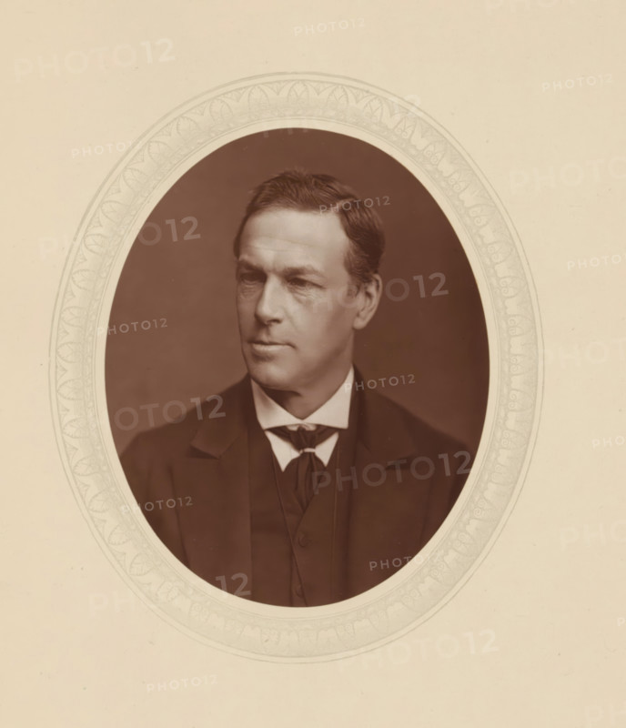 Sir Charles E. Pollock, page, photomechanical print, photographer: Lock & Whitfield, cliché maker: anonymous, c. 1876 - in or before 1881, paper, Woodburytype, Woodbury Process, height 115 mm x width 89 mm, Person, Charles Edward Pollock, magistracy, judges, historical persons (portraits and scenes from the life) ((full) bust portrait), A sepia oval portrait of a man set against a decorative oval border on a light background, showing a middle-aged man with neatly combed dark hair and a clean-shaven face, wearing a dark suit jacket, a vest, a white shirt with a high collar, and a dark bow-like necktie, his face turned slightly to the side with a neutral expression and the portrait framed within an ornate patterned mat.