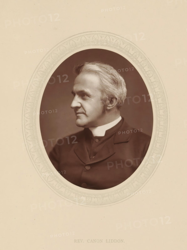 Rev. Canon Liddon, page, photomechanical print, photographer: Lock & Whitfield, cliché maker: anonymous, c. 1876 - in or before 1881, paper, Woodburytype, Woodbury Process, height 115 mm x width 89 mm, Person, Henry Liddon, theologian, historical persons (portraits and scenes from the life) ((full) bust portrait), An oval sepia portrait of an older man shown in profile facing left, with light-colored hair neatly combed back and short sideburns, wearing a dark jacket with a high white collar, set against a darker oval background and surrounded by a decorative light-colored oval border on a pale page.