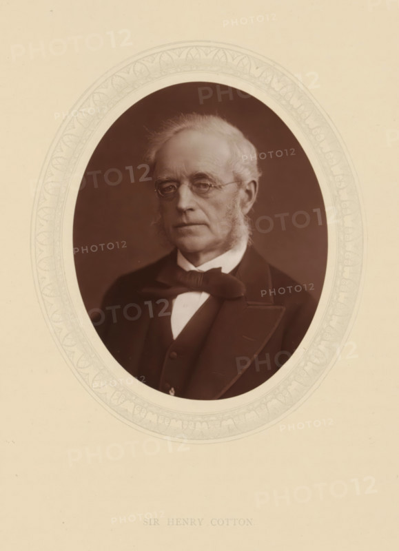 Sir Henry Cotton, page, photomechanical print, photographer: Lock & Whitfield, cliché maker: anonymous, c. 1876 - in or before 1881, paper, Woodburytype, Woodbury Process, height 115 mm x width 89 mm, Person, Henry Cotton, magistracy, judges, historical persons (portraits and scenes from the life) ((full) bust portrait), An oval portrait shows an older man with light hair and sideburns wearing round spectacles and a dark formal jacket with a bow tie and waistcoat; the portrait is set against a dark background and surrounded by a decorative light-colored oval mat with a patterned border, all on a larger light-colored sheet.