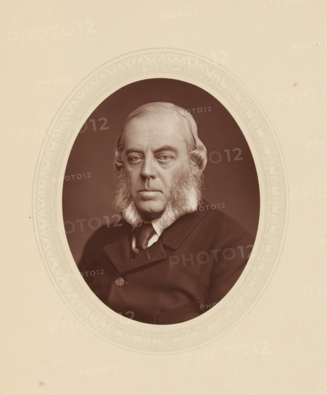 Duke of Marlborough, page, photomechanical print, photographer: Lock & Whitfield, cliché maker: anonymous, c. 1876 - in or before 1881, paper, Woodburytype, Woodbury Process, height 115 mm x width 89 mm, Person, George Spencer-Churchill, commander-in-chief, general, marshal, historical persons (portraits and scenes from the life) ((full) bust portrait), An oval sepia portrait of an older man with light hair and prominent sideburns, wearing a dark coat and a light-colored shirt with a visible collar, set against a dark background and framed by a decorative pale oval mat with a patterned border on a light beige backing.