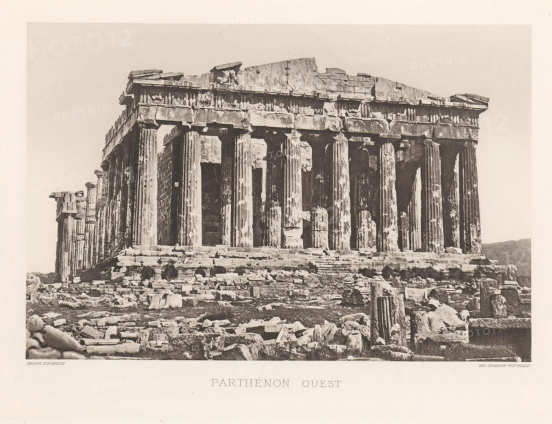 Parthénon ouest, Parthenon on the Acropolis of Athens, page, photomechanical print, Athens, cliché maker: Dujardin, printer (person): Chardon-Wittmann, c. 1880 - in or before 1890, photographer, printer (person), Athene, Periféreia Protevoúsis, paper, photoaquatint, height 145 mm x width 215 mm, ruin of a building, architecture, temple, shrine, Greek religion, Acropolis, Parthenon, A wide sepia photograph of an ancient stone temple façade showing tall fluted columns supporting a weathered entablature and partially ruined pediment, with chipped and eroded details on the column shafts and decorative frieze; broken stone blocks, column drums, and scattered rubble cover the stepped foreground and surround the base of the structure, while the sky behind the temple appears pale and unobstructed.