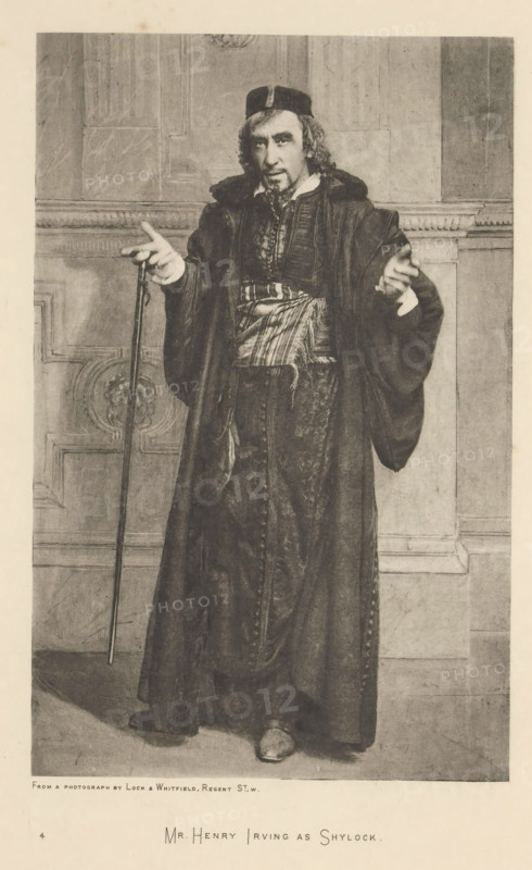 Mr. Henry Irving as Shylock, page, photomechanical print, photographer: Lock & Whitfield, cliché maker: anonymous, c. 1883 - in or before 1893, paper, photoaquatint, height 217 mm x width 139 mm, Person, Henry Irving, portrait of actor, actress, A black and white portrait of a man standing indoors against a paneled wall, wearing a long dark robe with wide sleeves and a patterned sash around his waist, a dark cap on his head, and a beard and mustache; he holds a thin staff in one hand while the other hand is raised with fingers extended, and his shoes are visible beneath the robe.