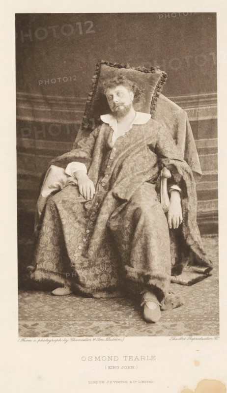 Osmond Tearle (King John), page, photomechanical print, photographer: Chancellor, Dublin, cliché maker: The Art Reproduction Company, publisher: Virtue & Co., London, c. 1880 - in or before 1890, Leinster, paper, photoaquatint, height 196 mm x width 121 mm, Person, portrait of actor, actress, A seated man wearing a patterned robe with a wide collar and large cuffs reclines against a cushioned chair with a fringed pillow behind his head; he has curly hair and a beard and his head tilts slightly to one side while one hand rests on his lap and the other hangs over the arm of the chair; the robe drapes over his legs and shows a row of buttons down the front, and he wears slippers with straps; a textured backdrop and carpeted floor are visible around the chair.
