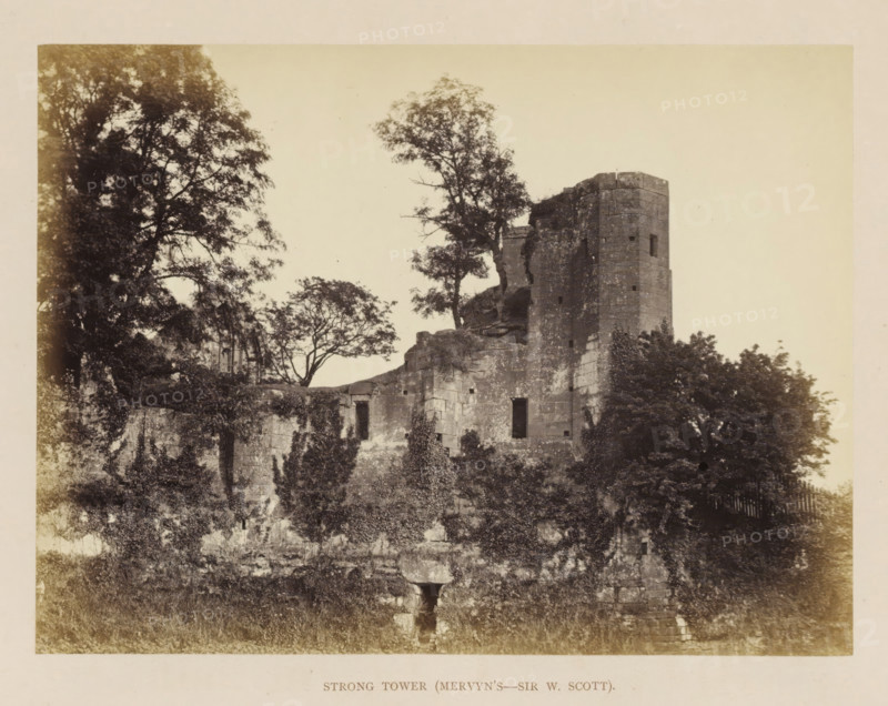 View of the ruins of the Strong Tower of Kenilworth Castle, Strong Tower (Mervyn's-Sir W. Scott), photograph, page, Kenilworth Castle, c. 1862 - in or before 1872, photographer, Kenilworth, paper, albumen print, height 152 mm x width 204 mm, ruin of a dwelling, house, castle, tower, clock tower, monumental adornment, A large stone ruin with a tall rounded tower and adjoining crumbling walls sits amid dense foliage, with trees growing behind and around the structure and vines climbing parts of the masonry, several rectangular openings visible in the stone, and a grassy foreground leading up to the weathered base of the ruin.
