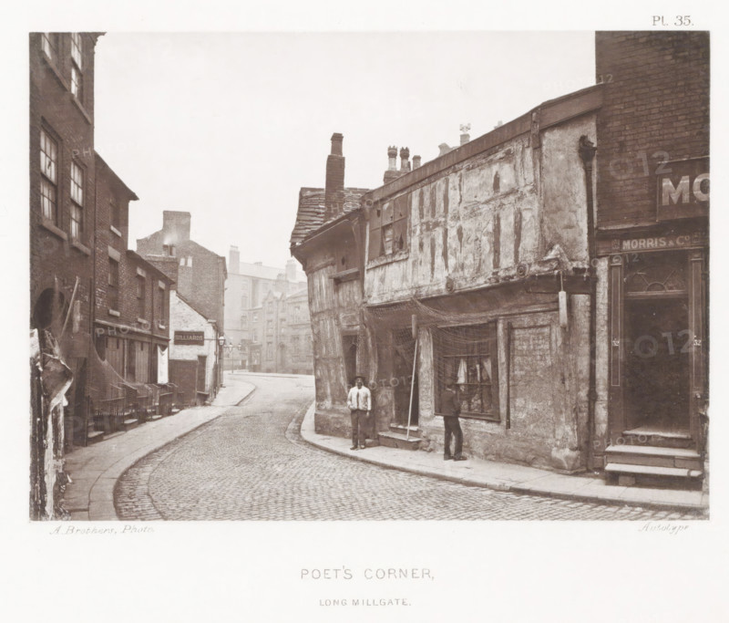 Poet's Corner, Long Millgate, View of Poet's Corner in Manchester, page, photomechanical print, number: 'Pl. 35.', photographer: Brothers, Alfred, Manchester, cliché maker: anonymous, c. 1868 - in or before 1878, printer (person), paper, collotype, photoprint, height 131 mm x width 183 mm, street, A narrow cobbled street curves between rows of old brick and timber buildings with visible wear and weathering; the building on the right projects over the pavement with exposed timbers, peeling plaster, a slanted tiled roof, and several chimney pots, while the left side shows multi-storey brick facades with windows and awnings and stacked chairs along the pavement; two men stand near the projecting building—one facing the camera and one looking into a shop window that displays small objects and fabric, and nearby a tall pole leans against the wall; further down the street more brick buildings and chimneys recede into a misty distance.