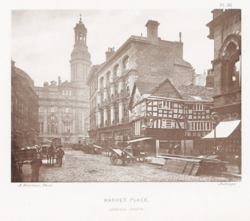 Market Place, looking south, View of Market Place in Manchester with a view of the tower of the Royal Exchange, page, photomechanical print, number: 'Pl. 36.', photographer: Brothers, Alfred, Manchester, cliché maker: anonymous, c. 1868 - in or before 1878, printer (person), paper, collotype, photoprint, height 138 mm x width 185 mm, market, hand-cart, tower, clock tower, monumental adornment, A sepia-toned street scene showing a cobbled road flanked by multi-story buildings of differing styles, including a timber-framed structure with visible exposed beams and small windows, and larger stone buildings with arched windows and decorative façades; a tall domed tower rises in the background with a lantern-like top, and a large brick chimney is visible atop one building; horse-drawn carts and a few people stand or walk along the street near wooden market stalls and piled planks; awnings extend over shopfronts and a projecting lamp hangs from one building; the sky appears pale and overcast.
