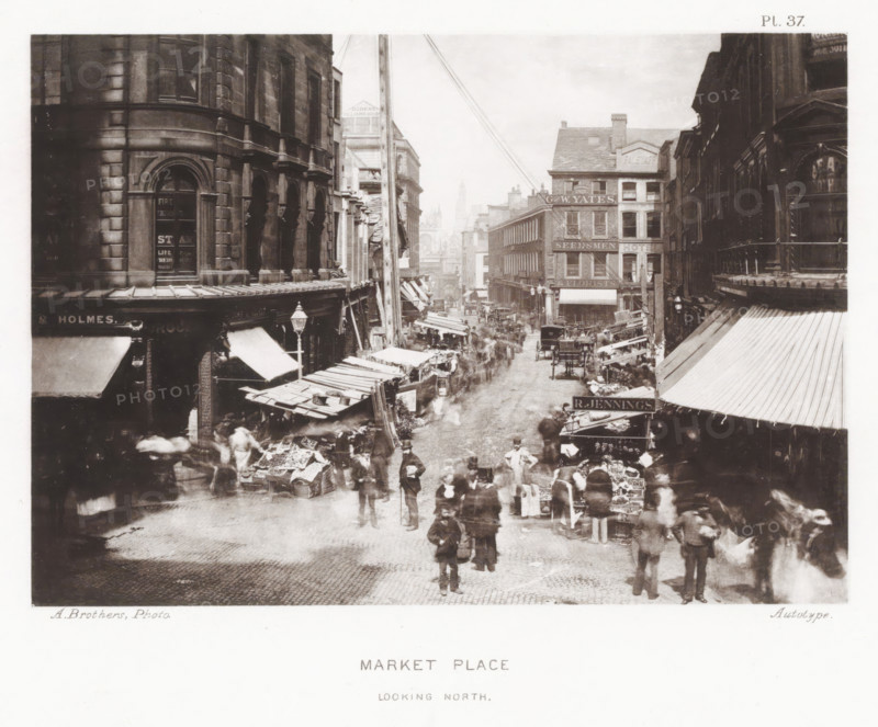 View of Market Place in Manchester, Market Place, looking north, page, photomechanical print, number: 'Pl. 37.', photographer: Brothers, Alfred, Manchester, cliché maker: anonymous, c. 1868 - in or before 1878, printer (person), paper, collotype, photoprint, height 135 mm x width 192 mm, Print after page 32., market, four-wheeled, animal-drawn vehicle, eg: cab, carriage, coach, A busy street scene viewed from above shows rows of multi-story stone and brick buildings lining a narrow cobbled roadway, with awnings and market stalls extending out from the shopfronts and many goods displayed on tables and in crates. People in period dress stand, walk, and browse among the stalls, some appearing blurred by motion, while a few men stand more clearly in the foreground. Horse-drawn carts and carriages are visible along the street amid clusters of pedestrians, and tall shop façades with windows and decorative architectural details rise on both sides. A tall wooden pole with wires runs up near th...