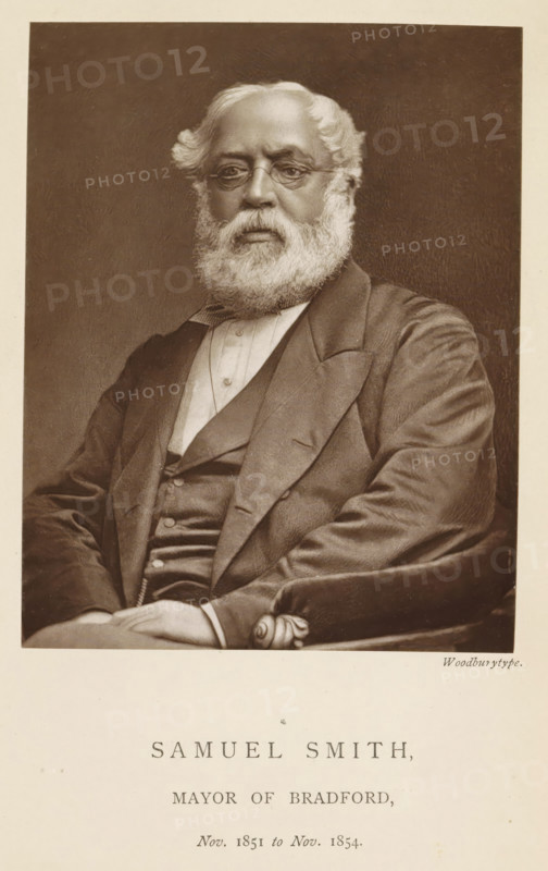 Portrait of Samuel Smith, Samuel Smith, mayor of Bradford, page, photomechanical print, inscription: 'Nov. 1850 to Nov. 1851.', photographer: Appleton & Co., Bradford (England), cliché maker: anonymous, c. 1871 - in or before 1881, paper, Woodburytype, Woodburytypepie, height 116 mm x width 91 mm, historical persons (portraits and scenes from the life) ((full) bust portrait), A seated older man with a full white beard and wavy white hair wears round spectacles and a dark suit with a waistcoat and a light shirt, his hands folded in his lap and one arm resting on an upholstered armrest, shown against a plain dark background.