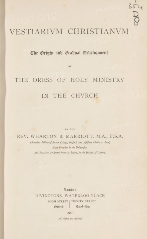 Vestiarium christianum the origin and gradual development of the dress of holy ministry in the church, book, inscription: 'ex libris SFJ', writer (clerical worker): Wharton Booth Marriott, publisher: Rivington, London, 1868, writer (clerical worker), textile materials, pasteboard, paper, linen (material), printing, albumen print, color on cut, lithography, woodcut, height 252 mm x width 161 mm x thickness 43 mm, A cream-colored aged book page with centered printed lines of large serif and blackletter type, showing a bold title near the top, a smaller decorative subtitle beneath it, and other lines of text descending the page; there are small brown spots and faint stains scattered across the paper, a vertical shadow or darker edge along the left margin, and a handwritten pencil mark near the top right edge.