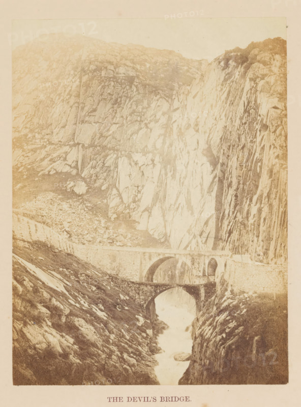 View of the Teufelsbrücke in the Gotthard Pass, The Devil's Bridge, photograph, page, photographer: Francis Frith, Gotthard Pass, c. 1855 - in or before 1865, Francis Frith, photographer, Gotthard pass, paper, albumen print, height 162 mm x width 122 mm, Photo opposite title page., bridge, A sepia-toned photograph showing a rocky mountainous landscape with steep cliffs and textured rock faces, a narrow river or stream running through a deep gorge, and two stone arch bridges spanning the water at different heights.