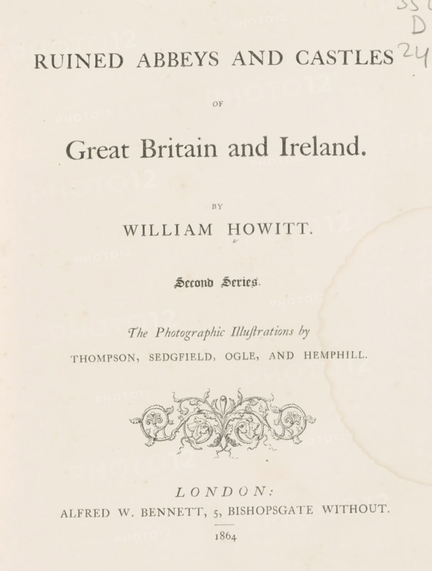 Ruined abbeys and castles of Great Britain and Ireland second series, book, name: 'Bound by Westleys & co London.', inscription: 'To Dear Mamma with her loving Daughter's best wishes A. ...th January 1. 1864', writer (clerical worker): William Howitt, publisher: Alfred William Bennett, London, 1864, William Howitt, Alfred William Bennett, writer (clerical worker), publisher, textile materials, paper, linen (material), albumen print, color on cut, height 226 mm x width 175 mm x thickness 25 mm, A cream-colored page with dark printed ornamental designs and type, showing a large decorative flourish near the center and a faded circular stain along the right edge, with smaller printed lines above and below and light spotting across the paper.