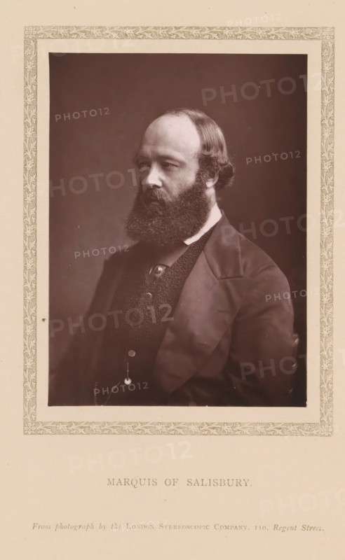 Marquis of Salisbury, page, photomechanical print, photographer: London Stereoscopic Company, London, c. 1876 - in or before 1881, printmaker, paper, Woodburytype, height 121 mm x width 85 mm, Person, Robert Gascoyne-Cecil (Marquis of Salisbury), politician, eg party leader, A sepia-toned portrait of a seated man shown from the chest up, framed by an ornate patterned border on a pale background. The man has a full bushy beard and a receding hairline with hair combed back over the sides, and he is turned slightly to his left with a neutral expression. He wears a dark suit jacket over a textured waistcoat with visible buttons and a small chain, and a white collar is visible at his neckline. The background behind him is plain and darker than the subject, creating contrast with the lighter mat surrounding the photograph.