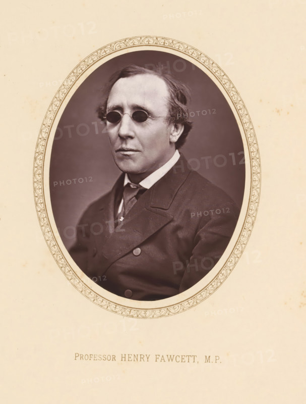 Professor Henry Fawcett, MP, page, photomechanical print, c. 1875 - c. 1880, photographer, printmaker, paper, Woodburytype, height 109 mm x width 81 mm, Person, Henry Fawcett, politician, eg party leader, An oval sepia photograph of a middle-aged man set against a plain darker background, framed by a decorative oval border on a light beige page; the man wears small round dark spectacles, has neatly combed hair with slight waves at the sides, a high-collared shirt with a tie, and a dark double-breasted coat with visible buttons and lapels, and his expression is neutral.