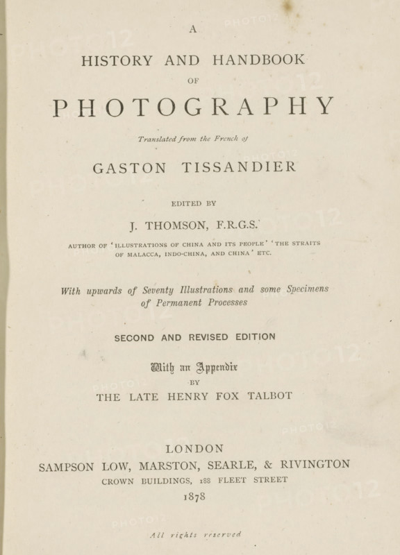 A history and handbook of photography, book, writer (clerical worker): Gaston Tissandier, writer (clerical worker): William Henry Fox Talbot, publisher: Sampson Low, Marston, Searle, & Rivington, London, 1878, writer (clerical worker), textile materials, pasteboard, paper, linen (material), printing, collotype, photoaquatint, height 198 mm x width 147 mm x thickness 35 mm, A vertically oriented aged book page with centered printed lines of varying font sizes and styles on an off-white, slightly stained background, showing a large bold title near the top, smaller italicized and capitalized lines beneath it, and several more centered lines of serif type descending the page with visible spacing between sections, all surrounded by plain margins and a faint darker edge along the left side.