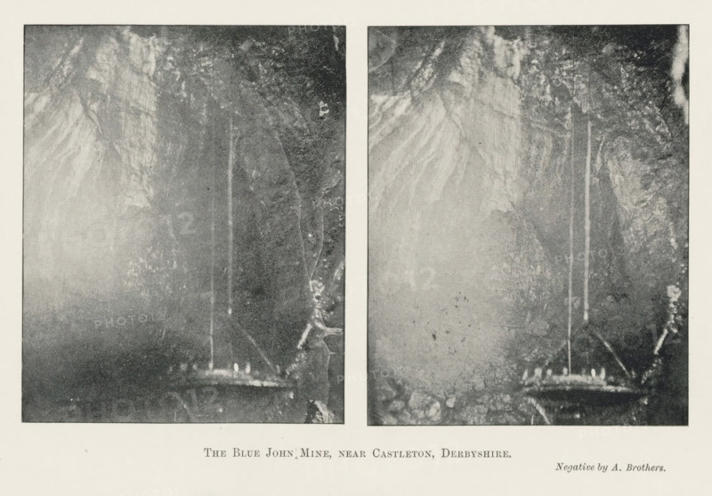 The Blue John Mine, near Castleton, Derbyshire, page, photomechanical print, photographer: Brothers, Alfred, Blue John Cavern, c. 1889 - in or before 1899, printmaker, paper, autotypie, height 151 mm x width 223 mm, cave, grotto, Two vertical rectangular black and white photographic panels sit side by side with a narrow white gap between them, each panel depicting a dark cave interior with rough textured rock walls and a vertical shaft of lighter tone running from near the top toward a lower platform area; the left panel shows a faintly illuminated rounded ledge at the bottom with small bright shapes suggesting lights, while the surrounding rock surfaces display mottled patterns and streaks, and the right panel mirrors similar cave features with a clearer view of rocky textures and the same vertical lighter column ending above a rocky ledge, all set against a wide pale border.