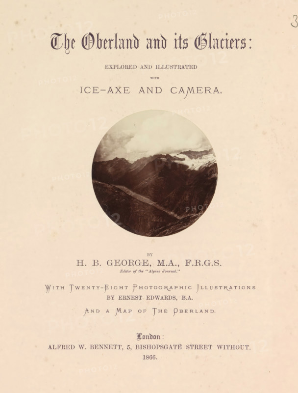 The Oberland and its glaciers : explored and illustrated with ice-ax and camera, book, inscription: 'June 1985', photographer: Ernest Edwards, writer (clerical worker): HB George, publisher: Alfred William Bennett, London, 1866, writer (clerical worker), textile materials, pasteboard, linen (material), paper, albumen print, printing, color on cut, height 275 mm x width 220 mm x thickness 30 mm, A single page with a pale cream background and scattered small brown flecks, featuring a circular sepia photograph of a mountain landscape with jagged dark ridges and a lighter snowy area near the top, positioned above a series of printed lines and decorative typography centered on the page.