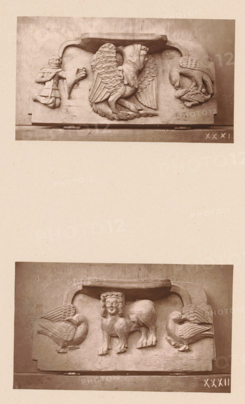 Two carvings in Worcester Cathedral, page, photomechanical print, Above a mythical creature between a figure and two birds of prey, below a sphinx between two birds., number: 'XXXI, XXXII', c. 1863 - in or before 1873, paper, Woodburytype, height 306 mm x width 244 mm, interior of church, fabulous animals (sometimes wrongly called 'grotesques'), 'Mostri' (Ripa), sphinx (lion, woman), 'Sfinge' (Ripa), carving, applied arts, A vertical image shows two separate rectangular stone relief panels mounted on a pale background, one near the top and one near the bottom. The upper panel features a central carved figure with wings and a hooded human head, flanked on the left by a small human figure and an animal head, and on the right by a bird-like creature facing downward that appears to be holding something in its beak. The lower panel depicts a central composite creature with a human head and a lion-like body standing between two large facing birds with rounded bodies and detailed feathering. ...