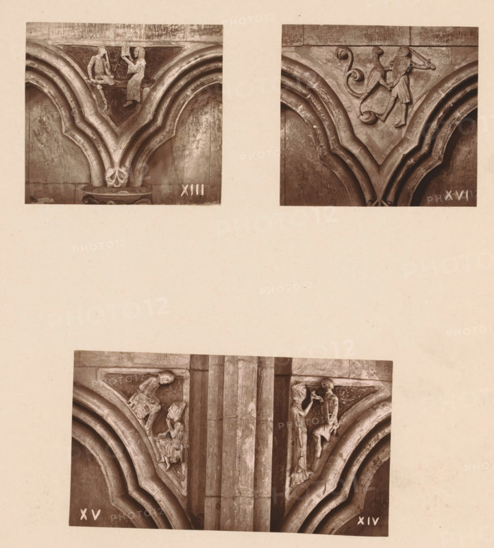 Three woodcarvings in an arcade of Worcester Cathedral, page, photomechanical print, Top left an architect shows his plans to a figure, top right a figure fighting a mythical creature, bottom a monk practicing a craft and a sculptor showing a sculpture., number: 'XIII, XVI', c. 1863 - in or before 1873, paper, Woodburytype, Woodburytypie, height 305 mm x width 244 mm, interior of church, man struggling with animals, carving, applied arts, architect offering design or model to patron, A paper with three sepia-toned photographs of carved stone architectural details mounted on it, showing the top pair of photographs side by side and a larger photograph centered below; the upper left photo displays a carved V-shaped arch with rounded mouldings and a small seated figure facing a standing figure on a ledge above the arch, the upper right photo shows a similar V-shaped arch with a carved figure holding a shield and another small decorative scroll motif above the arch, the lower photo shows a ...