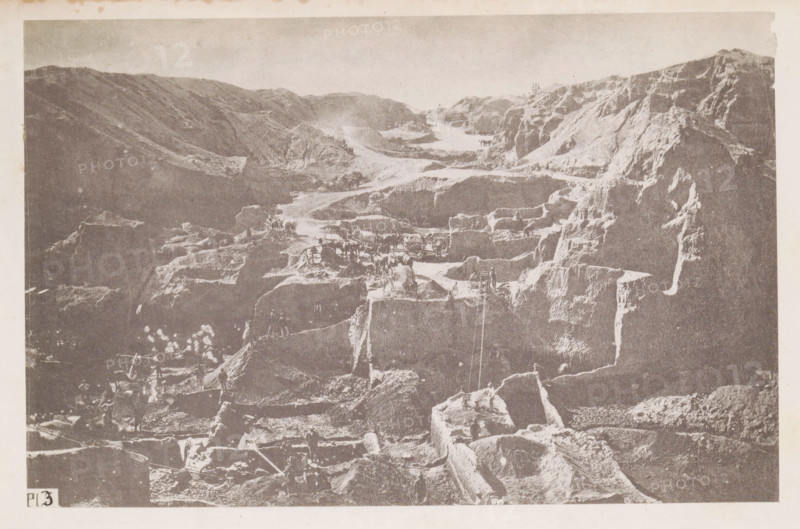 View of a diamond mine in South Africa, presumably near Kimberley, page, photomechanical print, number: 'Pl. 3', photographer: Gray Brothers (possibly), South Africa, c. 1870 - in or before 1880, paper, collotype, photogravure, height 125 mm x width 192 mm, Print in rear image section., mine, Kimberley, A monochrome image showing a rugged, terraced rocky landscape with steep cliffs and carved steps. The scene features a series of ledges and platforms cut into the rock, with visible tool marks and exposed strata. Small groups of figures stand and work on various levels, some near simple wooden frameworks and carts, and a few animals are present on the higher terraces. Narrow paths and ramps connect the different levels, and ropes or lines hang down one section of the rock face. The sky above is pale and unobstructed, and the image has a textured, aged appearance.