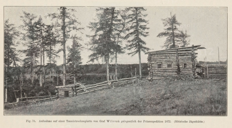 Exterior of a hunting hut in Siberia, Sibirische Jägerhütte, page, photomechanical print, inscription: 'Aufnahme, 1872.', number: 'Fig. 76.', photographer: Wilczek, Siberia, cliché maker: anonymous, c. 1900 - in or before 1905, paper, autotype, height 89 mm x width 179 mm, log-cabin, A wide landscape in muted tones shows a grassy foreground leading up to a rustic log building with visible horizontal logs and small square window openings, flanked by a low log fence that curves toward a cluster of tall, thin trees with sparse foliage; additional logs and stacked wood appear near the building, and a distant tree line stretches across the horizon under a pale sky.