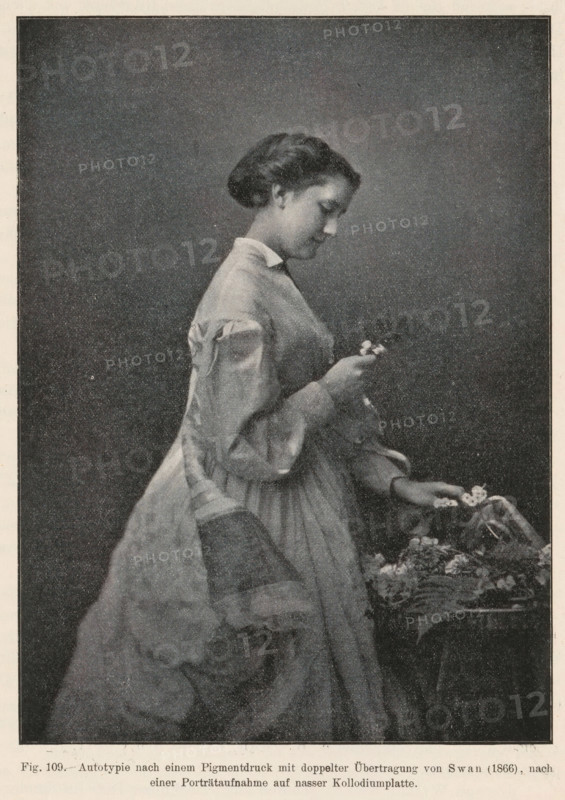 Portrait of a woman picking flowers, page, photomechanical print, inscription: 'Autotypie nach einem, auf nasser Kollodiumplatte', number: 'Fig. 109.', photographer: Joseph Wilson Swan, cliché maker: anonymous, c. 1900 - in or before 1905, paper, autotypie, height 145 mm x width 105 mm, flowers, adult woman, A monochrome image of a young woman in profile facing right, wearing a long dress with puffed sleeves and a high collar, her hair styled in a low bun; she is holding a small object near her chest with one hand while her other hand rests above a surface covered with flowers and fabric.