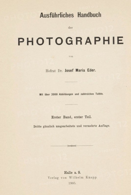 Geschichte der Photographie, book, writer (clerical worker): Josef Maria Eder, publisher: Wilhelm Knapp, Halle an der Saale, 1905, writer (clerical worker), Saxony-Anhalt, pasteboard, paper, printing, car type, height 245 mm x width 168 mm x thickness 30 mm, A cream-colored page with centered black printed headings and lines, featuring a large bold word in uppercase near the top, smaller bold and regular text lines above and below it, thin horizontal rules separating sections, and a decorative short horizontal ornament near the lower middle; the paper shows slight speckling and uneven discoloration.